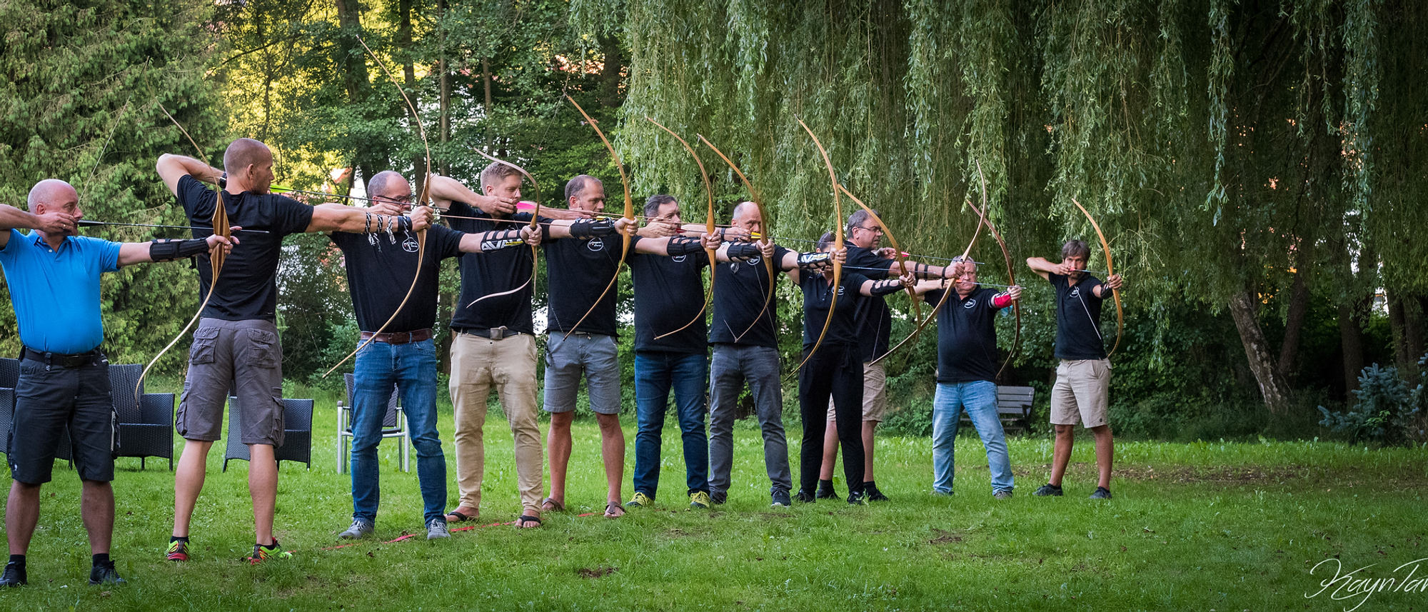Teamtraining im Freien: Gruppe beim gemeinsamen Bogenschießen